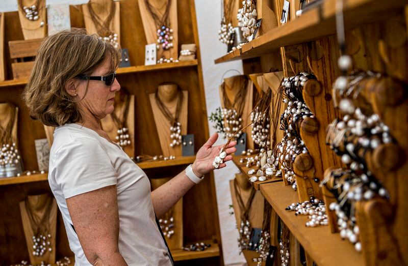 Ann Carey looks at necklaces designed by Eric Hicks during the 2015 Marietta StreetFest.
