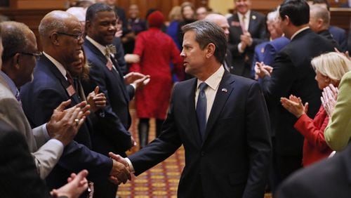 Gov. Brian Kemp is greeted by lawmakers as he enters the House chamber to deliver his first state of the state address. In it, he released his first budget, which included a $3,000 pay raise for teachers. The legislature eventually passed that bill and Kemp signed it into law. Bob Andres / bandres@ajc.com
