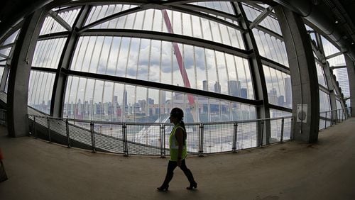 A worker passes by the “window to the city” in Mercedes-Benz Stadium, which will host college football’s national championship game Jan. 8. Curtis Compton/ccompton@ajc.com