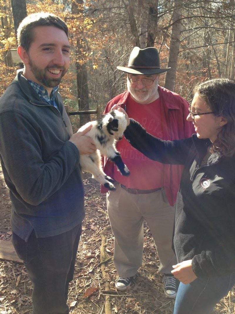 The baby goats are a chief attraction at the Blackberry Farmstead Thanksgiving gathering. Here, Bill King watches as his son Bill and daughter Olivia meet one of the farm babies. CONTRIBUTED BY JENNY ROBB-KING