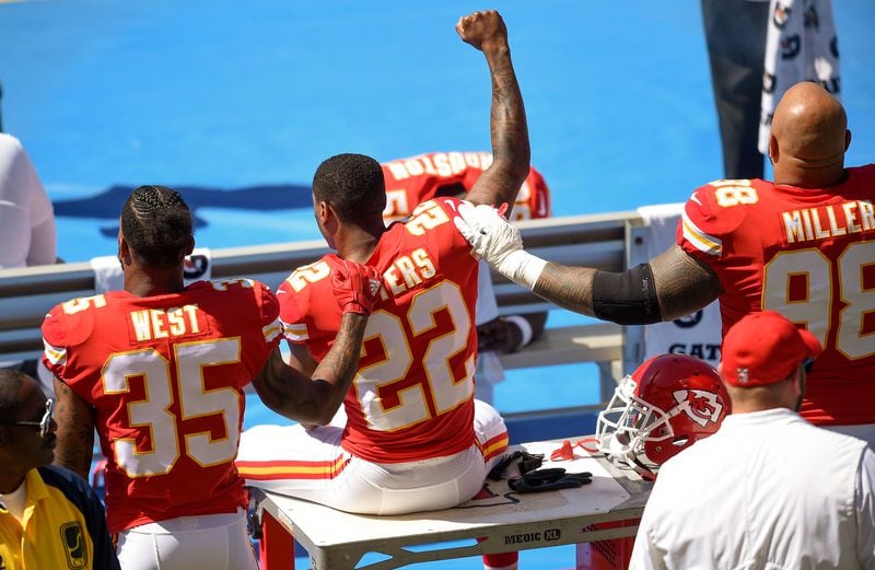 Kansas City Chiefs defensive back Marcus Peters (22) protests next to running back Charcandrick West (35) and defensive tackle Roy Miller (98) during the national anthem Sunday.