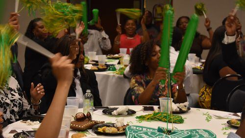 Several Ivy Prep Academy educators wave pom poms during a celebration Monday, May 8, 2017 for the school's first signing day for its teachers. PHOTO CONTRIBUTED