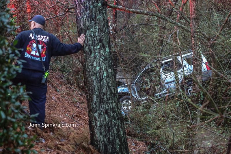 Atlanta firefighters worked to rescue a driver whose SUV got stuck in a creek's ravine Monday morning as widespread rain fell.