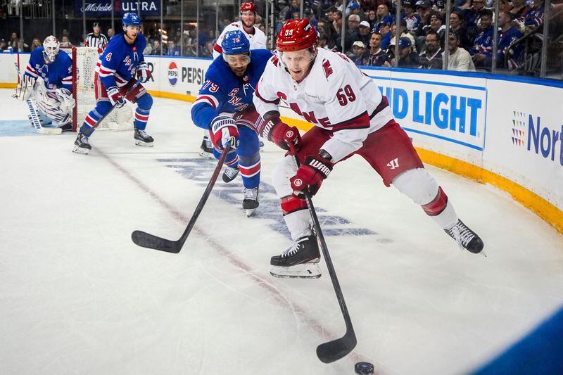 New York Rangers defenseman K'Andre Miller (79) and Carolina Hurricanes center Jake Guentzel (59) fight for the puck during the first period in Game 2 of an NHL hockey Stanley Cup second-round playoff series, Tuesday, May 7, 2024, in New York. (AP Photo/Julia Nikhinson)