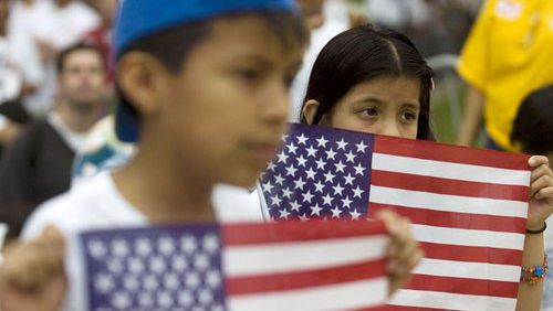 In 2010, Jason Rosales, 10, and his sister Jessica Rosales, 8, of Norcross, hold American flags during a march in support of immigration reform in downtown Atlanta.