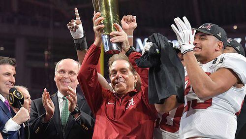 Alabama coach Nick Saban holds up the championship trophy during College Football Playoff Championship game at Mercedes-Benz Stadium in January. Alabama came back from a 13-point second half to defeat Georgia 26-23 in overtime. HYOSUB SHIN / HSHIN@AJC.COM