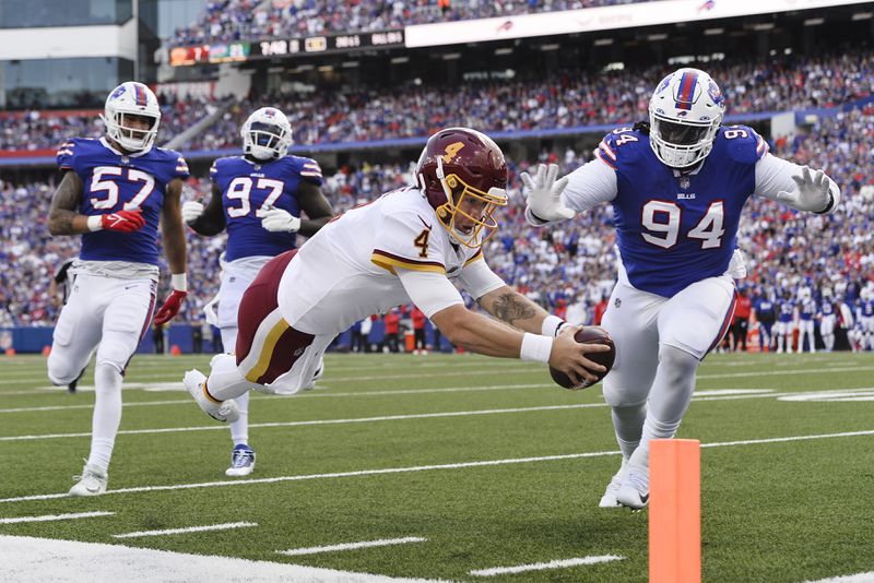 Washington quarterback Taylor Heinicke dives past Buffalo's Vernon Butler for a touchdown as the Bills' A.J. Epenesa (57) and Mario Addison (97) watch. In 2020, Epenesa was the rage until he ran a 5.04 in the 40-yard dash at the combine. He went 54th to Buffalo in the second round. (AP Photo/Adrian Kraus)