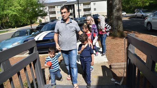 Yaser Musa walks back to his family’s apartment home with his five children: (from left) Mohamad, 3, Issa, 5, Samar, 10, Nor Alhoda, 12, and Reem, 11, on April 13, 2017. HYOSUB SHIN / HSHIN@AJC.COM