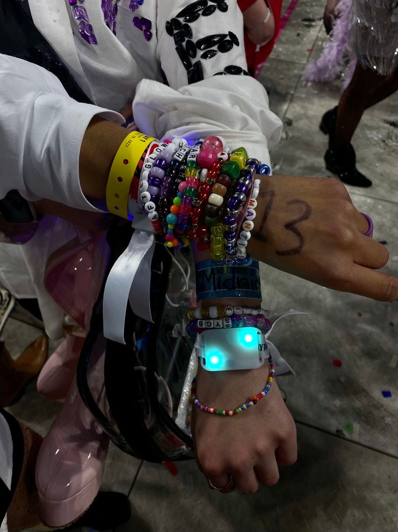 Amanda Owen and Enid McCarthy show off handmade multiple bracelets with popular song titles and sayings to trade with other fans at the sold-out Taylor Swift concert at Mercedes-Benz Stadium in Atlanta on Friday, April 23, 2023.  (Kelly Audette / Kelly.Audette@ajc.com)