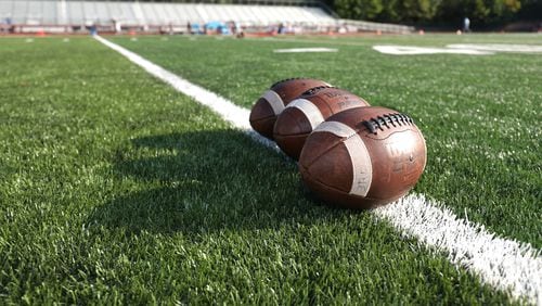 Footballs are lined up on the field prior to the Lovett-GAC high school football matchup on Sept. 11. (Jason Getz/Special to the AJC)