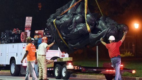 Workers remove a monument dedicated to the Confederate Women of Maryland early Aug. 16, 2017, after it was taken down in Baltimore. Local news outlets reported that workers hauled several monuments away, days after a white nationalist rally in Virginia turned deadly.