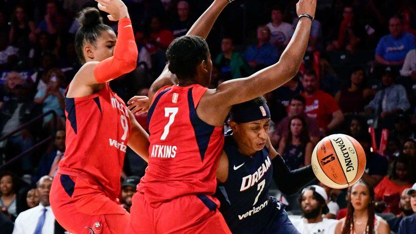 Dream guard Brittney Sykes (7) drives against Washington Mystics guard Ariel Atkins (7) and guard Natasha Cloud, left, during the first half of Game 5 of a WNBA basketball playoffs semifinal Tuesday, Sept. 4, 2018, in Atlanta. (AP Phot