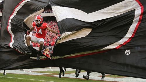 Georgia senior safety Dominick Sanders leads the team through the "G" banner to take on Kentucky Saturday, Nov. 18, 2017, in Athens.