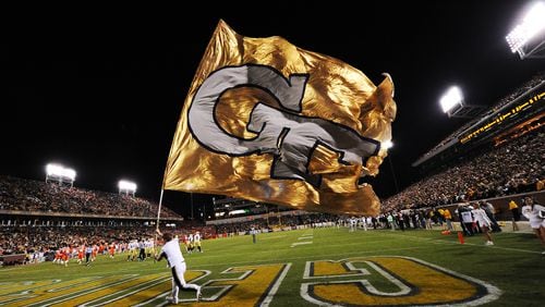 A Georgia Tech cheerleader carries a GT flag on the field after Georgia Tech scored a touchdown against Clemson at Georgia Tech on Saturday, Oct 29, 2011. Johnny Crawford // AJC file
