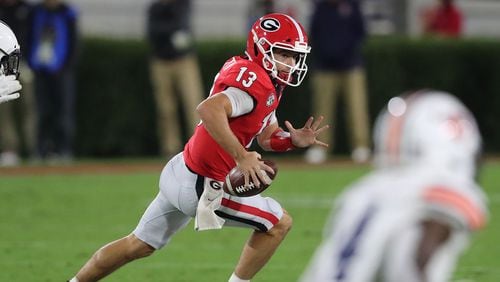 100320 Athens: Georgia quarterback Stetson Bennett rolls out to complete a pass and avoid the pressure from Auburn during the first half in a SEC college football game on Saturday, Oct 3, 2020 in Athens.   “Curtis Compton / Curtis.Compton@ajc.com”