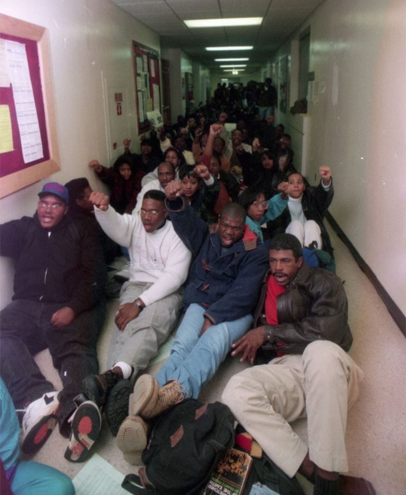 Students raise their fists as they stage a sit-in protest in the basement of GSU's Sparks Hall on Nov. 9, 1992. (Marlene Karas / AJC Archive at the GSU Library)