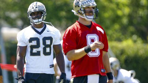 New Orleans Saints running back Adrian Peterson (28) stands behind quarterback Drew Brees (9) during NFL football practice in Metairie, La., Thursday, May 25, 2017. (AP Photo/Derick E. Hingle)