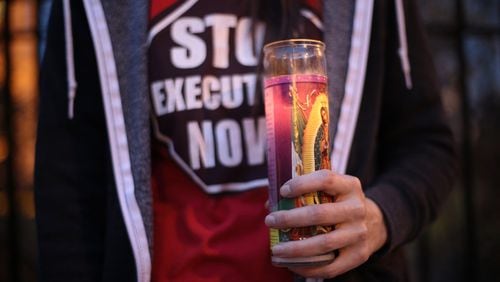 Ashley Petty holds a candle at a protest against the death penalty on March 2, 2015, on the steps of the state Capitol in Atlanta. BEN GRAY / BGRAY@AJC.COM