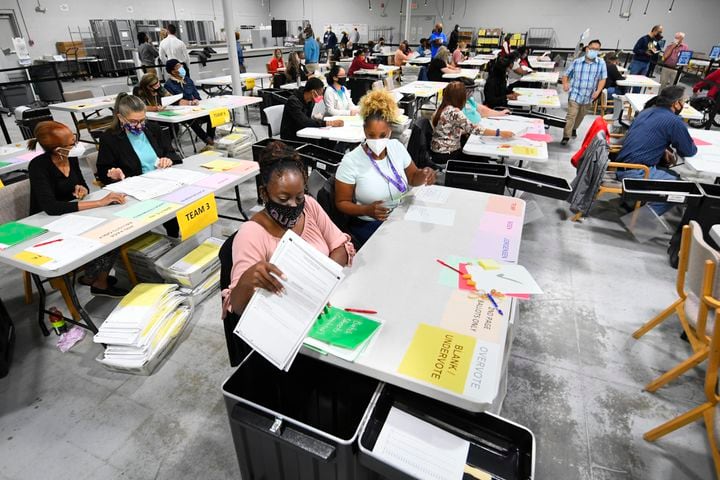 An election worker pulls ballots out of a case to count as votes for President are recounted at the Gwinnett County elections office on Friday, Nov.13, 2020 in Lawrenceville. (JOHN AMIS FOR THE ATLANTA JOURNAL-CONSTITUTION)