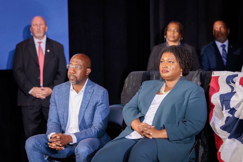U.S. Sen Raphael Warnock and Stacey Abrams listen to former President Barack Obama speak in Atlanta at a rally for Democratic candidates on Oct. 28, 2022. (Arvin Temkar/The Atlanta Journal-Constitution/TNS)