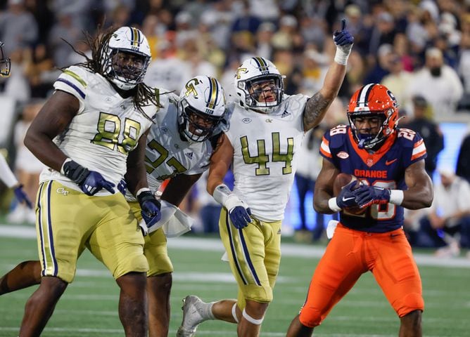 Georgia Tech Yellow Jackets defensive lineman Zeek Biggers (88), defensive lineman Josh Robinson (27) and linebacker Kyle Efford (44) celebrate after stopping Syracuse Orange running back Juwaun Price (28) on third down during the second half of an NCAA college football game between Georgia Tech and Syracuse in Atlanta on Saturday, Nov. 18, 2023.  Georgia Tech won, 31 - 22. (Bob Andres for the Atlanta Journal Constitution)