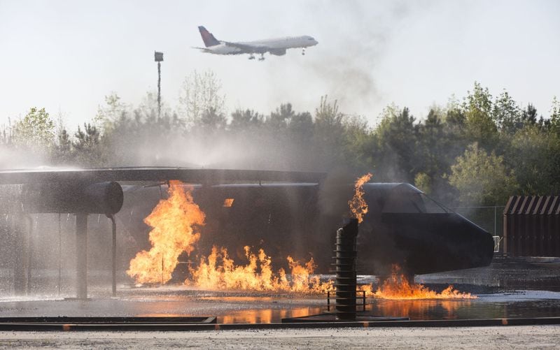 A Delta plans landed behind a burning fuselage as Hartsfield-Jackson International Airport held a full-scale disaster drill with Atlanta Firefighters, law enforcement, rescue personnel and nearly 150 volunteers who participated in a triennial exercise known as âBig Birdâ on Thursday, April 12, 2018. Airport personnel mobilized to a mock aircraft crash, extinguished the fire then triaged & treated the victims at a training site. The Federal Aviation Administration requires airports to conduct annual emergency preparedness drills and at least one full-scale drill every three years. (Photo by Phil Skinner)NOTE: getting Ids was impossible because the media was too far away.