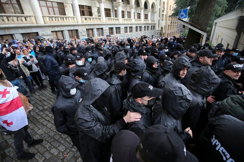 Demonstrators watch as police leave an area around the Parliament building during an opposition protest against "the Russian law" in the center of Tbilisi, Georgia, on Monday, May 13, 2024. Daily protests are continuing against a proposed bill that critics say would stifle media freedom and obstruct the country's bid to join the European Union. (AP Photo/Zurab Tsertsvadze)