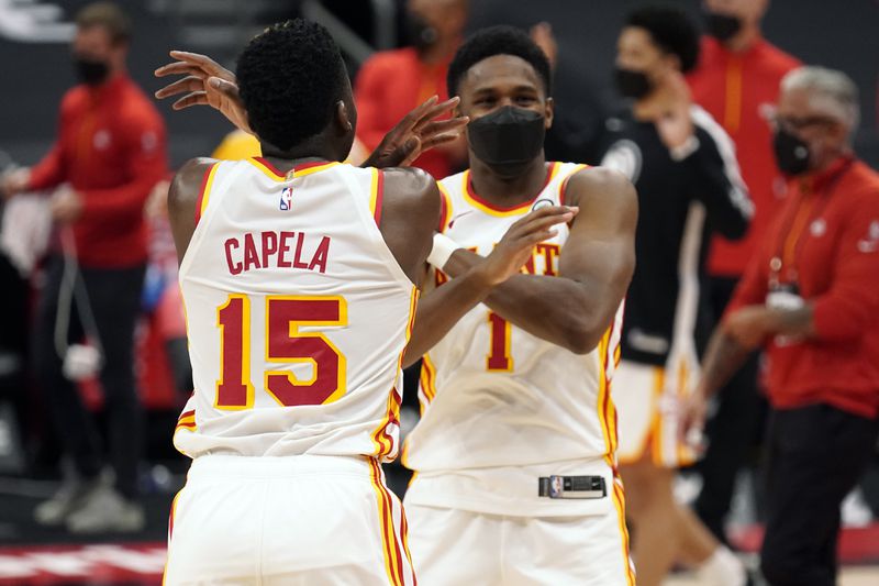 Atlanta Hawks center Clint Capela (15) and forward Nathan Knight (1) celebrate their win over the Toronto Raptors during an NBA basketball game Tuesday, April 13, 2021, in Tampa, Fla. (AP Photo/Chris O'Meara)