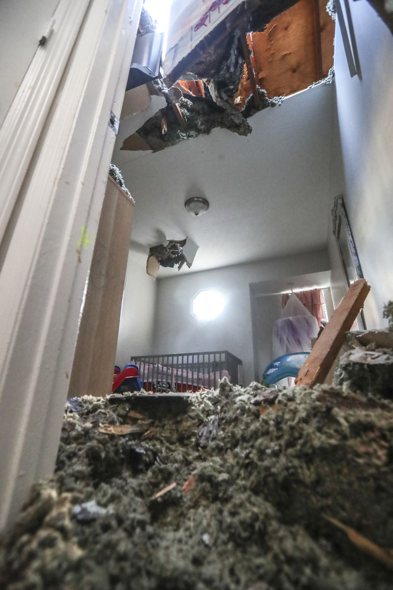 Ashlee Johnson said she stopped pushing on the door to her daughter's room after she realized a hole in the ceiling above her crib was widening. She had to wait for help from DeKalb County fire crews. (John Spink / John.Spink@ajc.com)