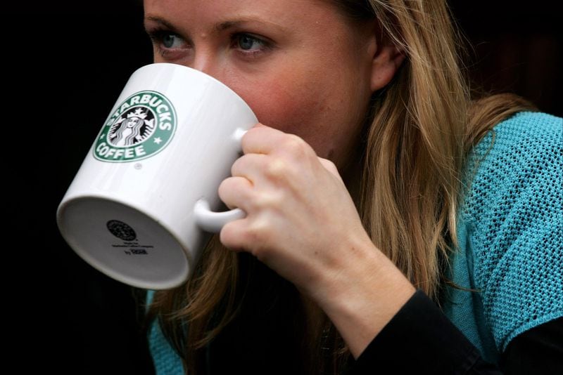 FILE PHOTO: A woman drinks from a coffee mug in a Starbucks.