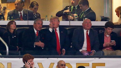U.S. President Donald Trump talks to Arthur Blank, owner of the Atlanta Falcons, and his wife Angie, during the game between the Georgia Bulldogs and Alabama Crimson Tide in the CFP National Championship presented by AT&T at Mercedes-Benz Stadium on January 8, 2018 in Atlanta.