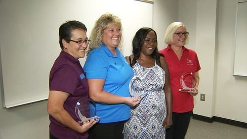 From left: Bus drivers Cindy Johnston and Sandy Purcell along with Dee Walls (far right) used CPR to save the life of co-worker Felina Canon (in the dress) at a training class earlier this month. WSBTV