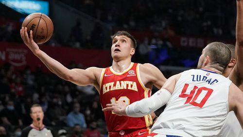 Hawks' Bogdan Bogdanovic, left, drives to the basket past Los Angeles Clippers' Ivica Zubac, right, during first half of an NBA basketball game Sunday, Jan. 9, 2022, in Los Angeles. (AP Photo/Jae C. Hong)