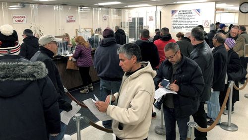 People line up to pay their real estate taxes before the end of the year, hoping for one last chance to take advantage of a major tax deduction before it is wiped out in the new year. The tax overhaul signed last week by President Donald Trump puts a new $10,000 limit on the amount of state and local taxes people can deduct from their income when calculating their federal tax liability. (Howard Schnapp/Newsday via AP)