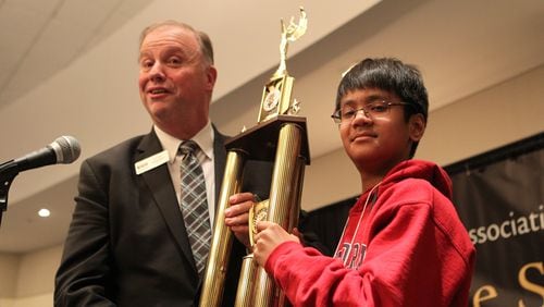 March 17, 2017, Atlanta, Georgia - The winner of the State Spelling Bee, Abhiram Kapaganty, stands and holds his trophy up alongside Dr. Sid Chapman, the president of the Georgia Association of Educators in Atlanta, Georgia, on March 17, 2017. (HENRY TAYLOR / HENRY.TAYLOR@AJC.COM)