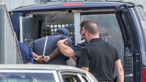 Kenneth Carson, Antonio Denson and Larry Tyler are loaded into an Atlanta Police prisoner transport van as they are arrested at the Atlanta Department of Watershed Management Pipe Yard off of Peyton Road in Atlanta on Monday, May 18, 2015. Carson, Denson, Tyler and a fourth employee, Aaron Avery, are charged with theft by taking as part of an ongoing internal and external investigation. The four are accused of exchanging water meters, copper and brass at recycling centers.