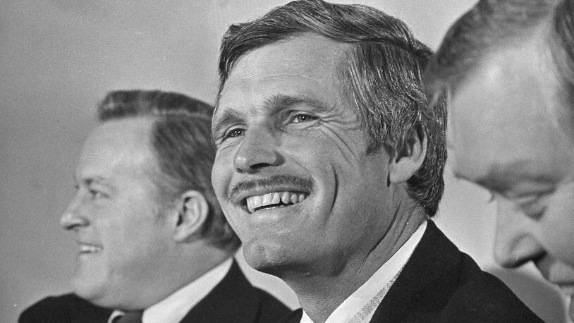 Ted Turner, Atlanta advertising and television executive, smiles after it was announced that he purchased the Atlanta Braves, Jan. 6, 1976, in Atlanta. Purchase price for the team was not disclosed but it was reportedly in the $10 million range. Turner is flanked by club chairman Bill Bartholomay, left, and president Dan Donahue. (AP Photo/Charles E. Kelly)