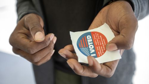 A voter holds an “I voted” sticker after casting a ballot. (Francine Orr/Los Angeles Times/TNS)