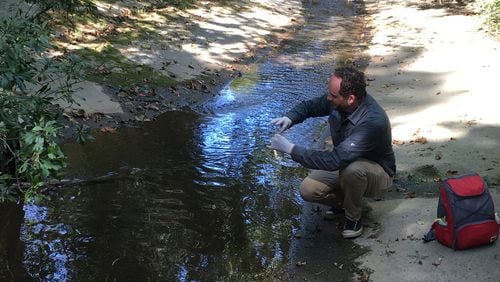Mike Meyer, program director of Chattahoochee Riverkeeper Neighborhood Water Watch program, takes samples from Proctor Creek. With the help of citizen water monitors, the group has been tracking contamination levels in the creek for almost a decade. Photo Credit: Nedra Rhone