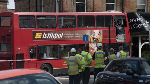 Police , firemen and emergency workers on the scene of a bus accident in southwest London on Thursday..