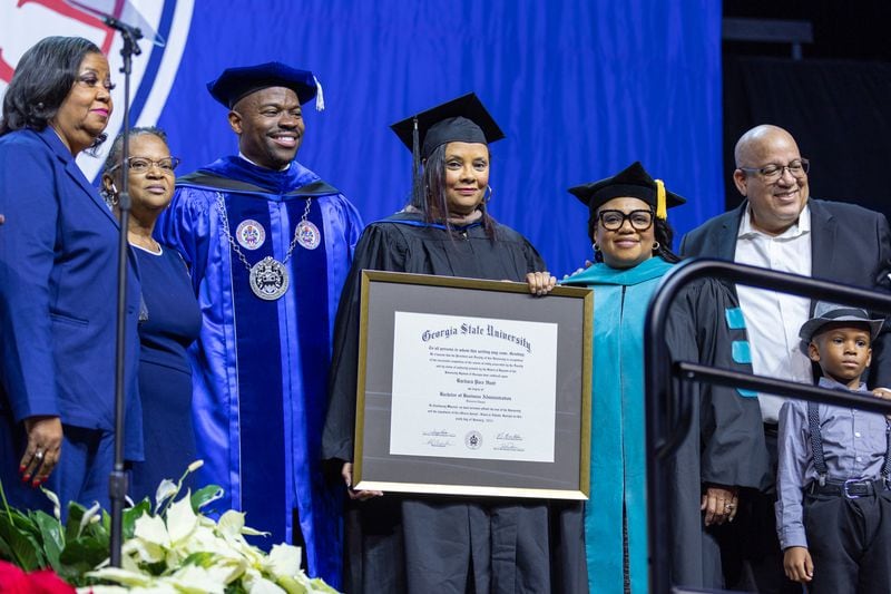 Crystal Freeman receives an honorary degree on behalf of her mother, Barbara Pace Hunt, at Georgia State University’s graduation ceremony in Atlanta on Wednesday, Dec. 14, 2022. GSU presented honorary degrees to three Black women who sued to integrate the school but never enrolled. (Arvin Temkar / arvin.temkar@ajc.com)
