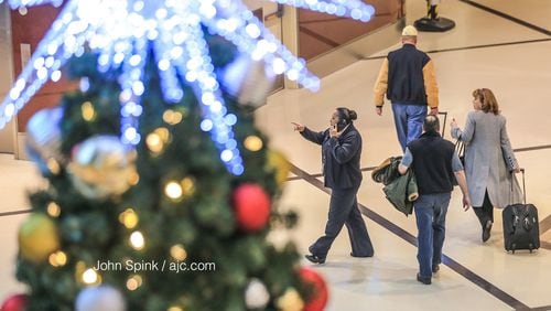 Travelers head through Hartsfield-Jackson International Airport in Atlanta on Friday as Christmas weekend begins.