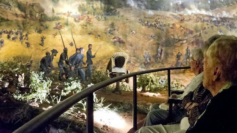 Visitors in this 2013 photograph look at different scenes from the Battle of Atlanta depicted in the Cyclorama painting in Grant Park. The attraction is closing at the end of June in preparation for its relocation and restoration at the Atlanta History Center.. JONATHAN PHILLIPS / SPECIAL