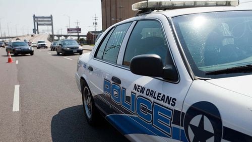 A New Orleans police car is parked on a city bridge. A shootout Sunday night between officers and an armed robbery suspect left the suspect dead and five bystanders injured by gunfire.
