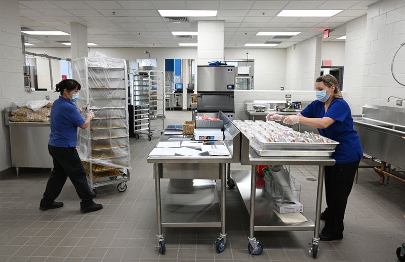 Yanailys Lugones (left) and Hanh Zimmerman, both kitchen staff, prepare school meals on Tuesday, Aug. 2, 2022, prior to the first day of school at brand-new Seckinger High School in Buford. (Hyosub Shin / Hyosub.Shin@ajc.com)