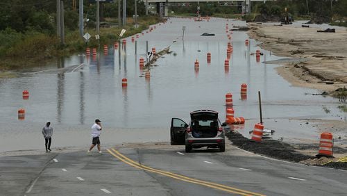 A couple find President Street, which leads to the Islands Expressway to Tybee Island, blocked by flood waters during Hurricane Matthew on Saturday, Oct. 8, 2016, in Savannah. Curtis Compton /ccompton@ajc.com