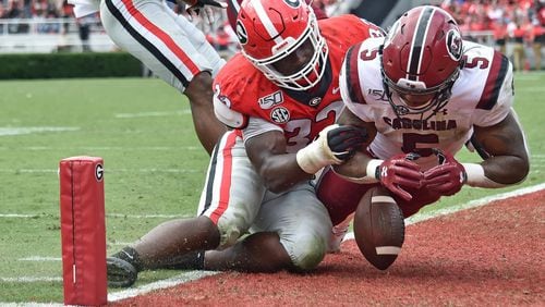 Georgia linebacker Monty Rice (32) stops South Carolina running back Rico Dowdle (5) as he dives into the end zone in overtime at Sanford Stadium in Athens on Saturday, October 12, 2019. (Hyosub Shin / Hyosub.Shin@ajc.com)