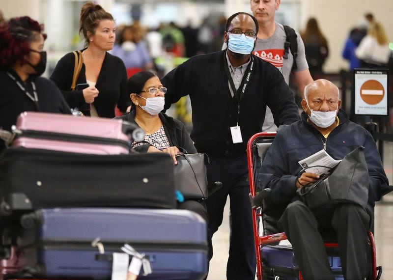Passengers who need assistance wear masks as they return from Amsterdam in the International Terminal at Hartsfield-Jackson International Airport.(Curtis Compton/Curtis.Compton@ajc.com)