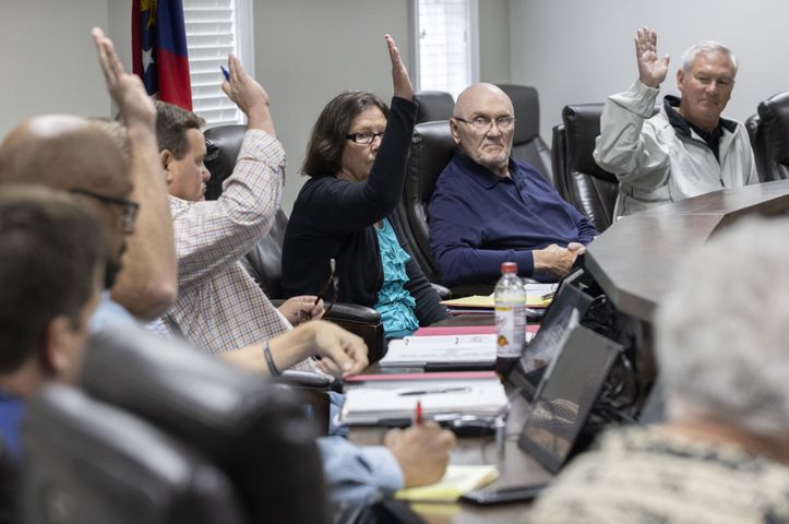 Mary Ellen Anton (center) calls for a vote as the Morgan County board of assessors approve the Rivian tax exemption proposal in Madison on Wednesday, May 25, 2022. John Artz (center right) opposed the measure.  (Bob Andres / robert.andres@ajc.com)