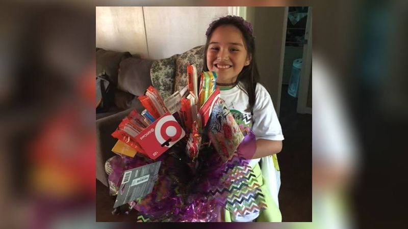 Diana Romero holds gifts given to her by Gwinnett County Sheriff's deputies. The girl's mother, Isabel Martinez, stabbed Diana's dad and four siblings.